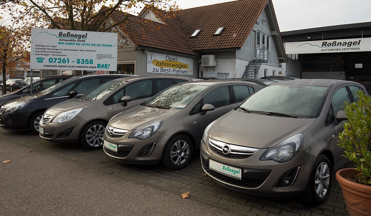 Mehrere Fahrzeuge stehen nebeneinander vor dem Rossnagel Automobile Haus und einem Schild
