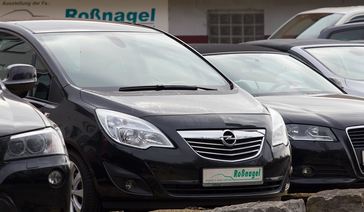 Mehrere dunkelfarbige Fahrzeuge stehen nebeneinander.